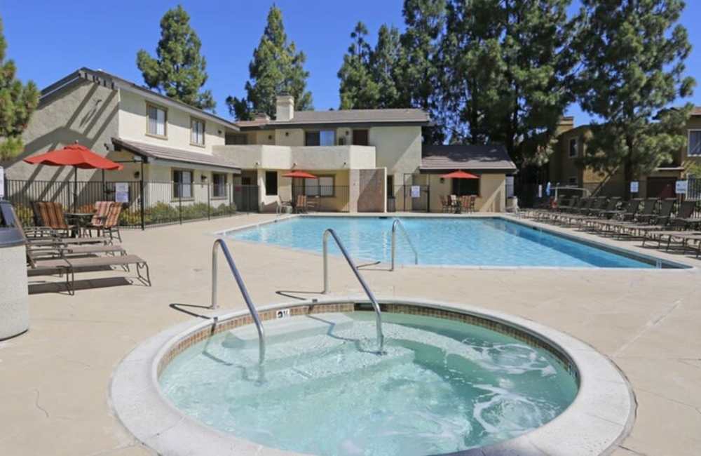Spacious community swimming pool, hot pool and sun loungers at Countryside Apartments in Poway, California