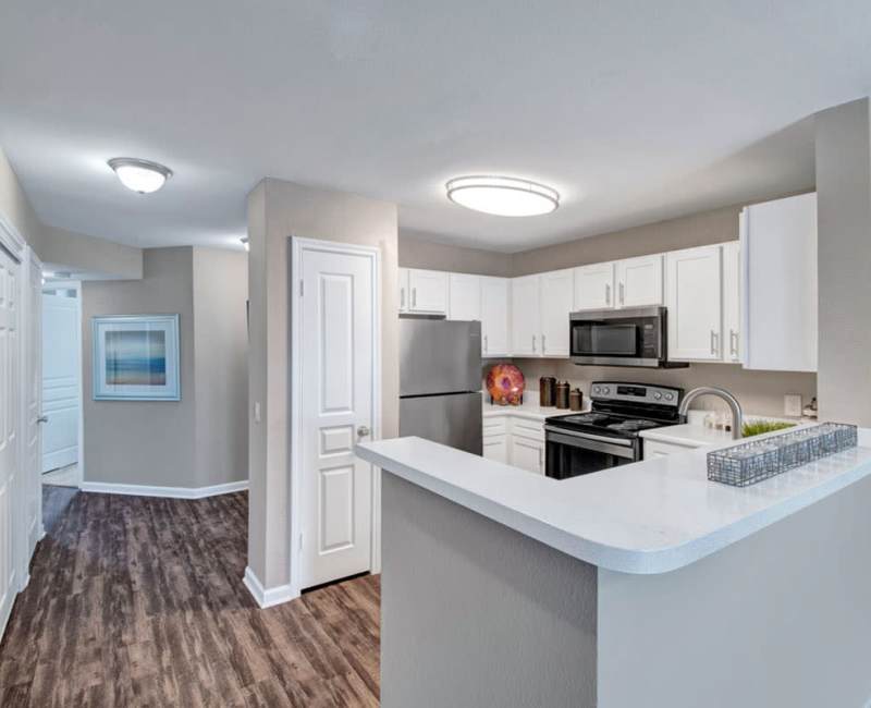 Modern kitchen with extra storage and a dual-basin sink in a model home at Arbrook Park Apartment Homes in Arlington, Texas