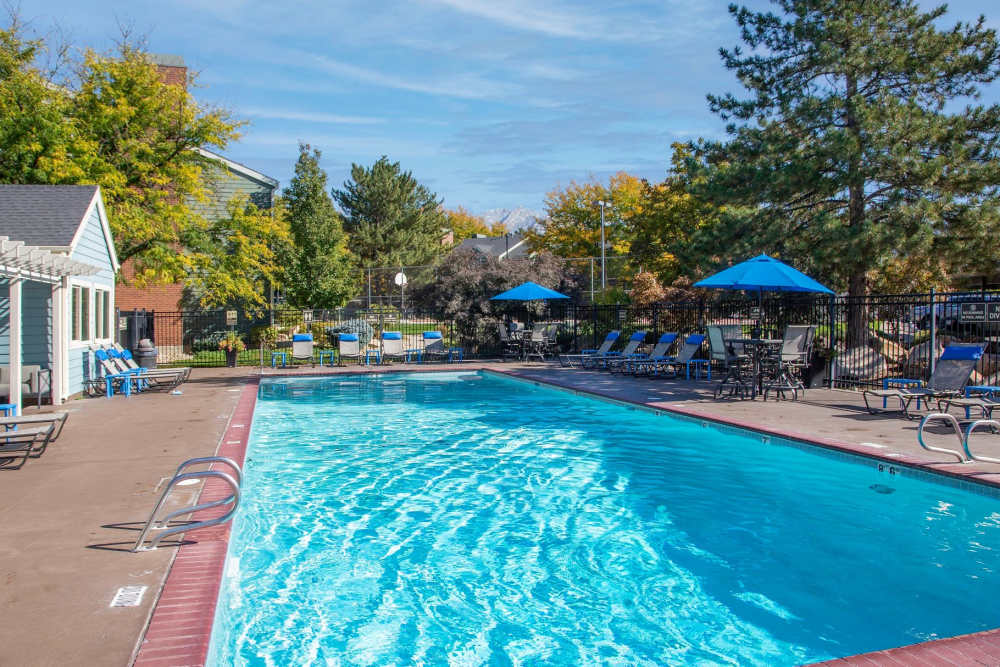 Swimming pool with lounge chairs at Royal Ridge Apartments in Midvale, Utah