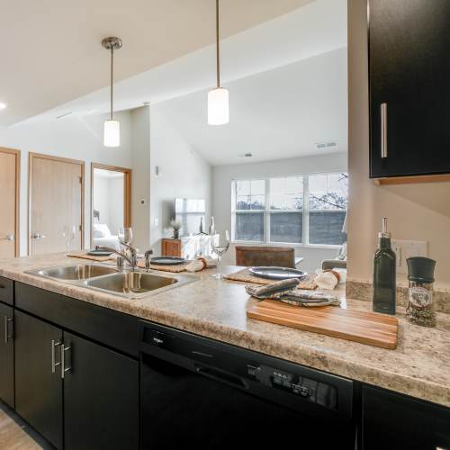 Modern kitchen with wooden cabinets, granite countertops and stainless-steel appliances at Whitetail Ridge in Salem, Wisconsin
