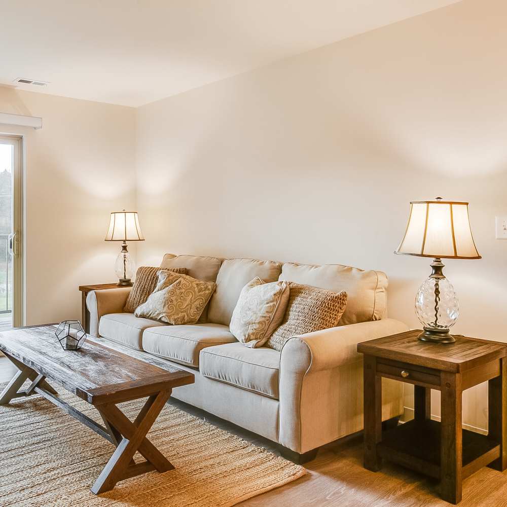 Spacious living room with a couch and table at Chelsea Commons in Sugar Grove Illinois