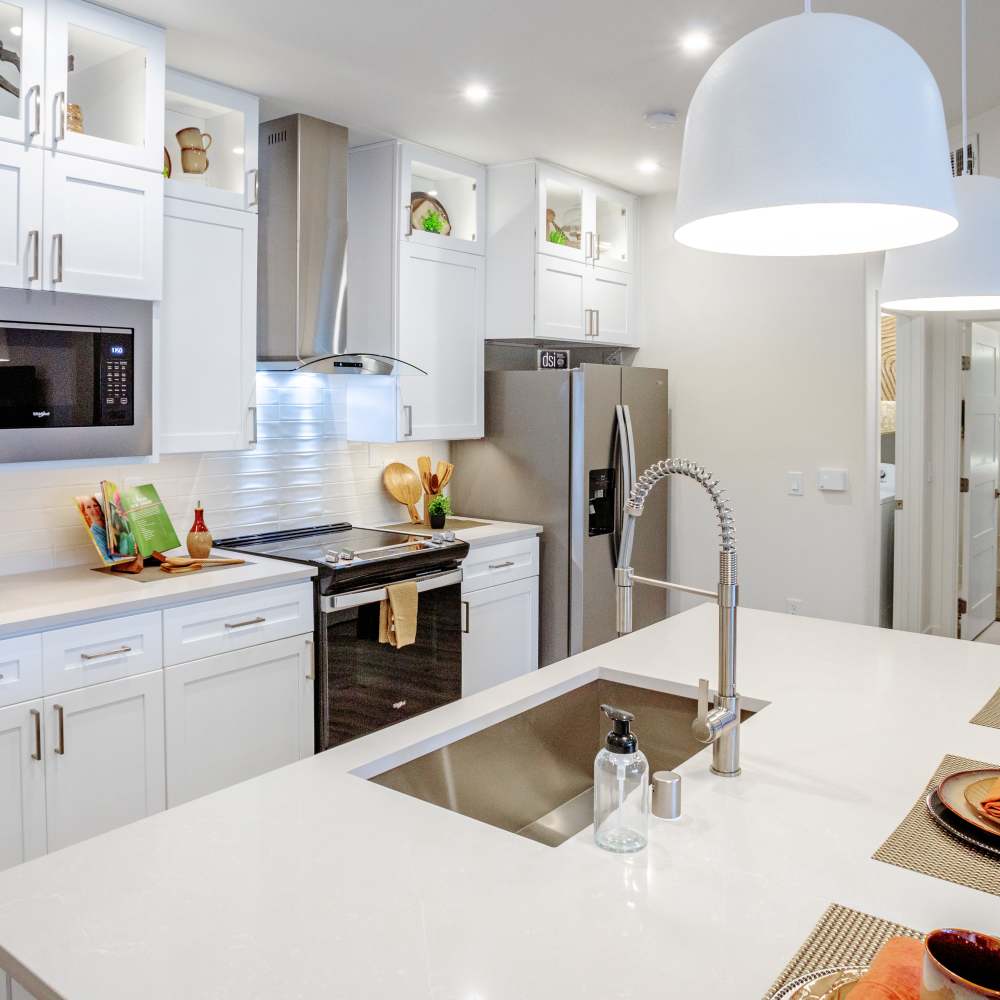 Kitchen with island countertop and white cabinetry at Night Fall in Las Vegas. NV