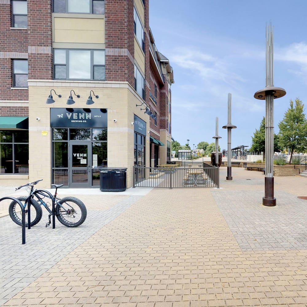 Retail shops at street level with cobblestone sidewalks outside at Oaks Station Place in Minneapolis, Minnesota