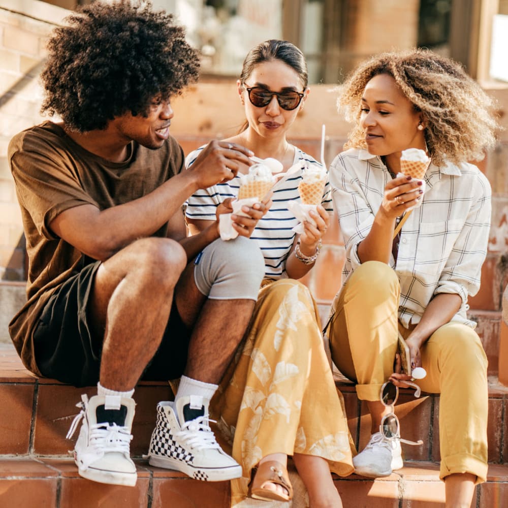 Resident friends on a downtown step enjoying ice cream near Oaks Station Place in Minneapolis, Minnesota