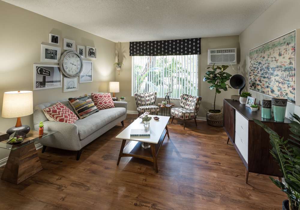 Comfortable living room with hard wood flooring at UCE Apartment Homes in Fullerton, California
