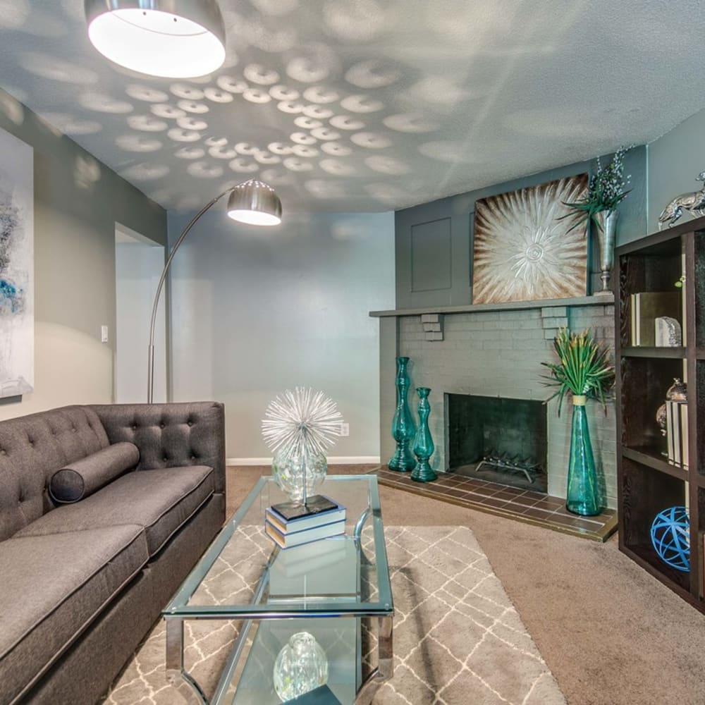 Living room with plush carpeting and a fireplace at London House Apartments in Lenexa, Kansas