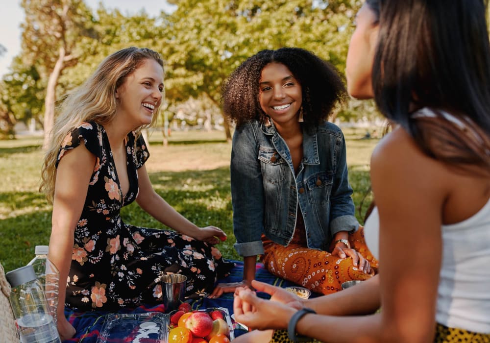 Resident friends enjoying a picnic at the park near Eddison at Deerwood Park in Jacksonville, Florida
