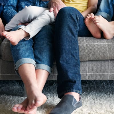 Happy family's feet on the couch in their new home at Sofi at Somerset in Bellevue, Washington