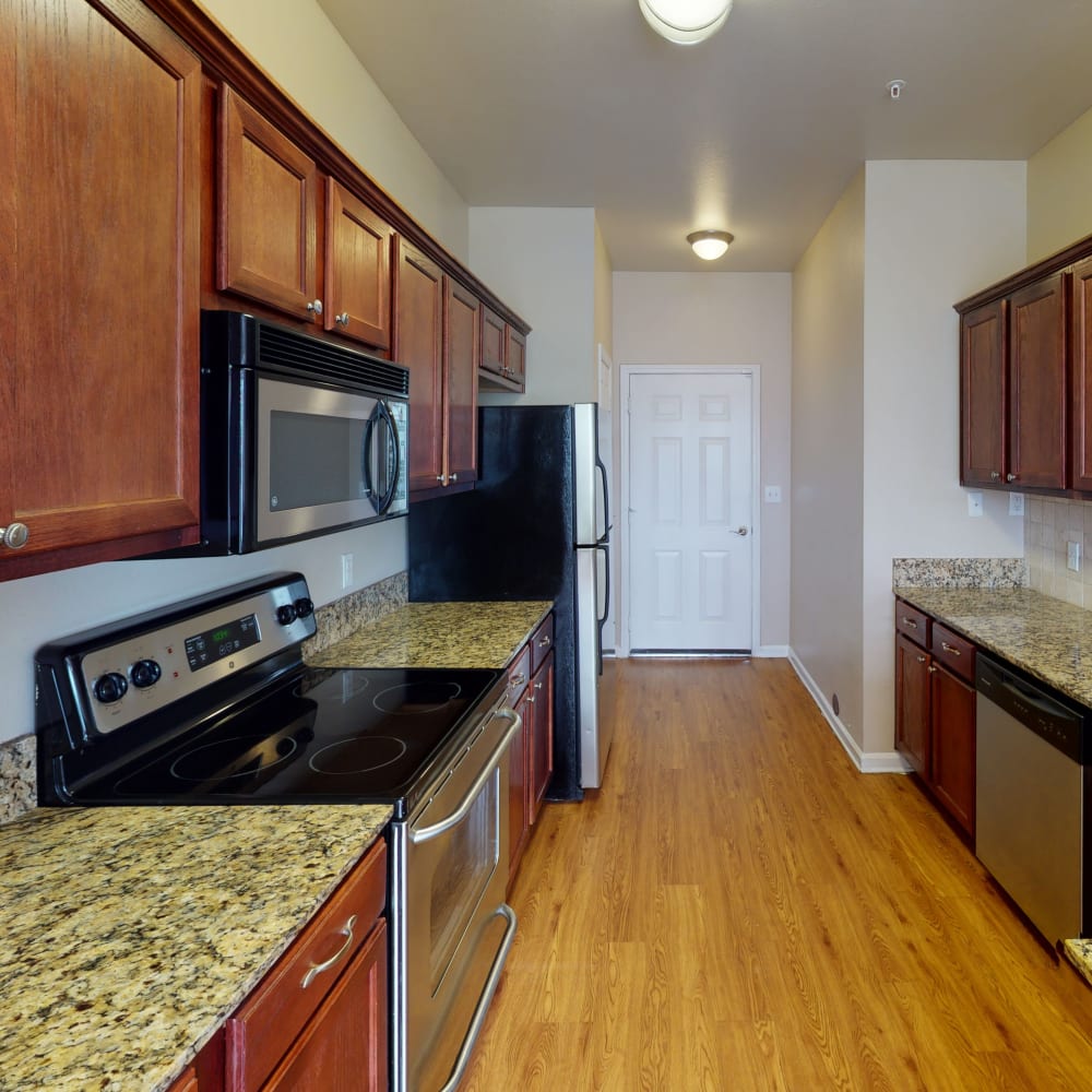 Modern kitchen with granite countertops in a townhome at Oaks Estates of Coppell in Coppell, Texas