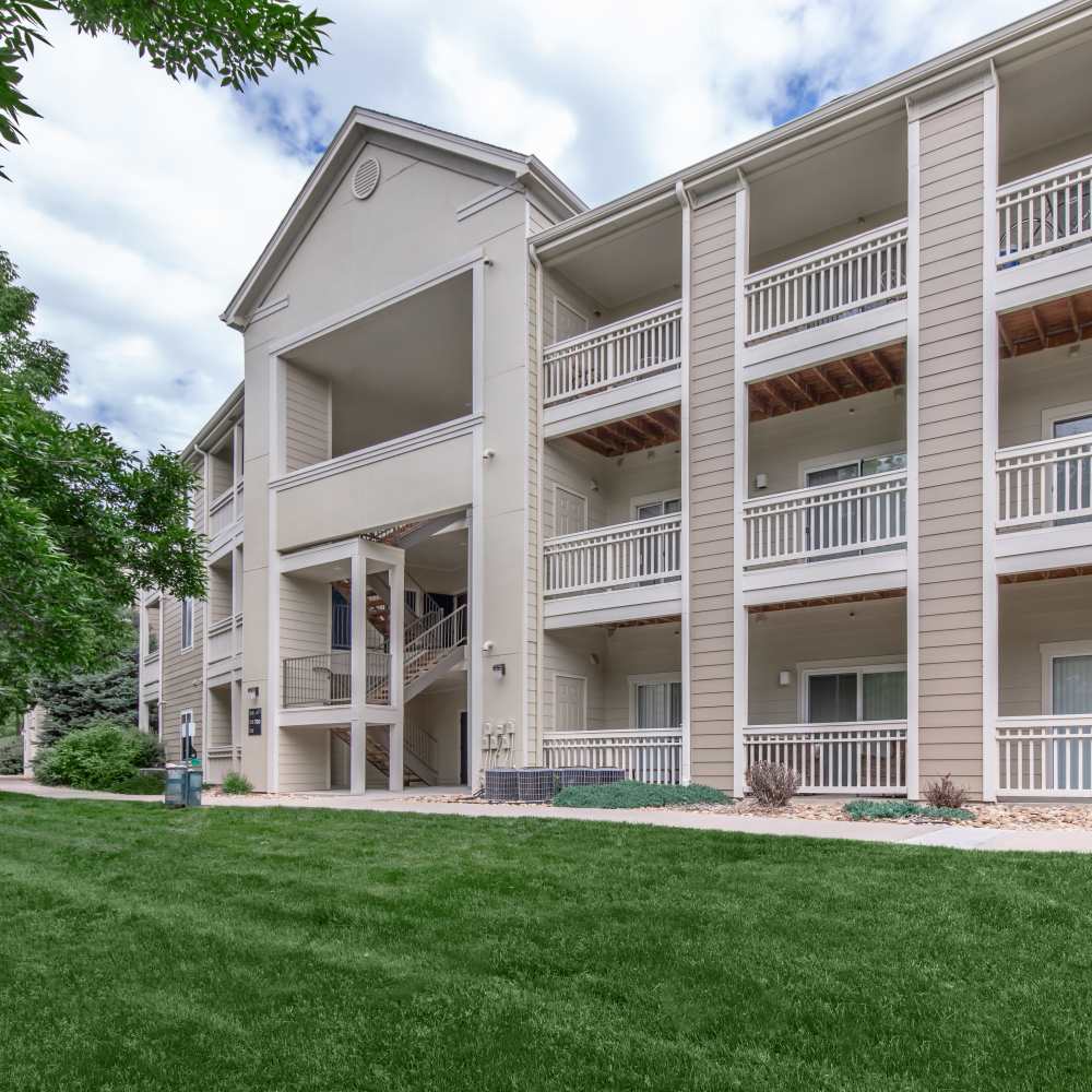 Side view of community with green lawn in front at One Belmar Place in Lakewood, Colorado