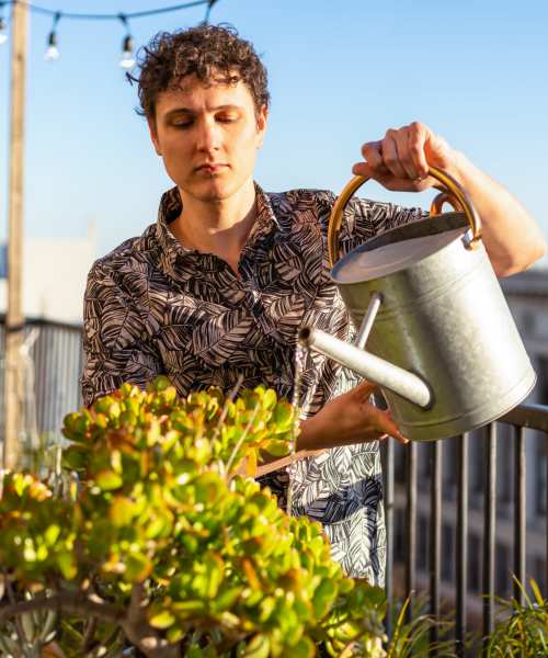 Resident watering plants at Sagewood Estates in Portland, Oregon