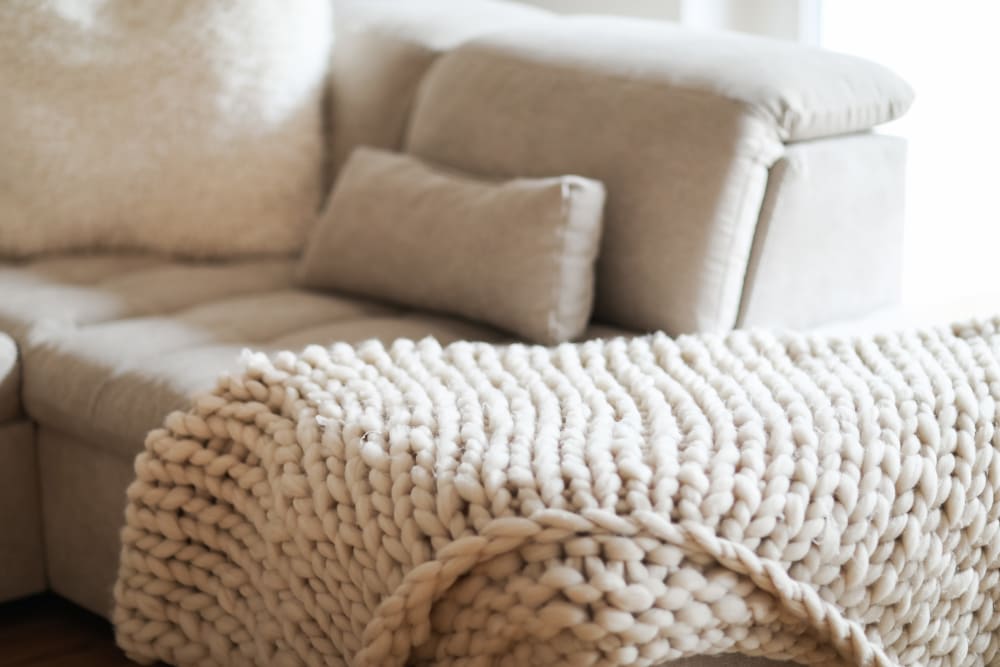 couch with blanket at Cornfield Apartments in Ellington, Connecticut