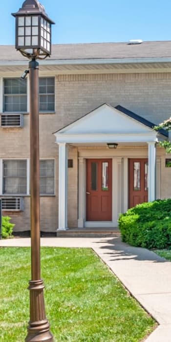 Front entrance with greenery at Cloverdale Park Apartments in Saddle Brook, New Jersey