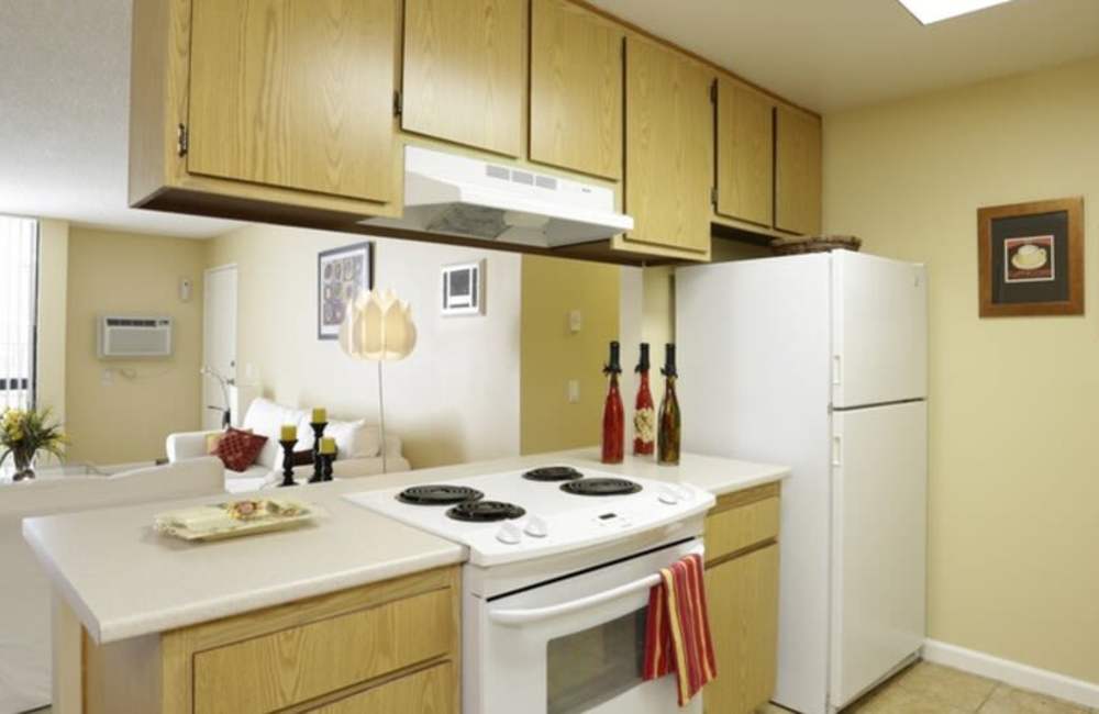 A well-equipped kitchen with refrigerator and microwave at Countryside Apartments in Poway, California