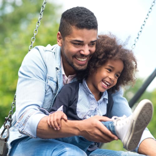 A father pushing his son swing at park near Chollas Heights Historical in San Diego, California