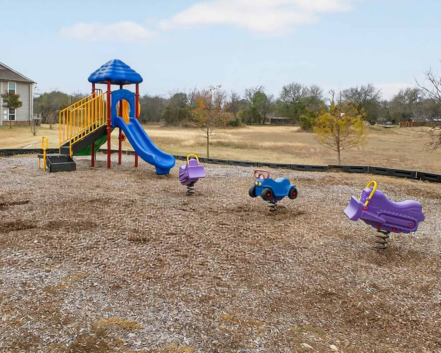 Charming playground with vibrant slides and springy rides at Lakewood Crossing in Granbury, Texas.