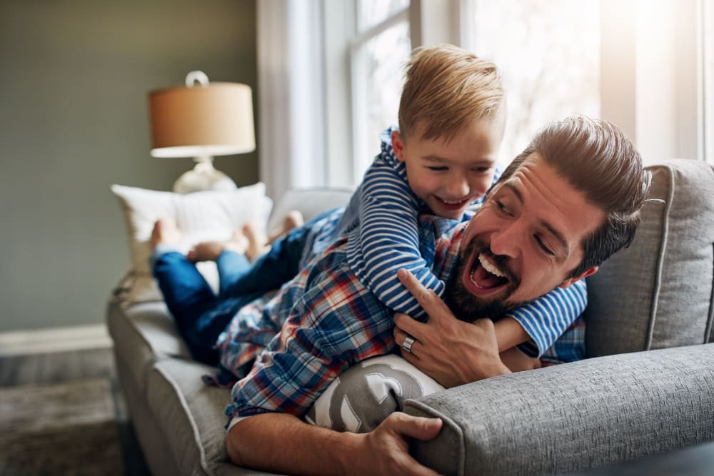 Resident father and son enjoying time together in their apartment at Gentian Court Apartments in Columbus, Georgia