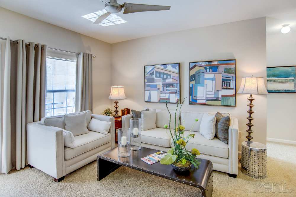 Comfortable living room with wall art, sofa and coffee table at Highland Hills Apartments in Dothan, Alabama