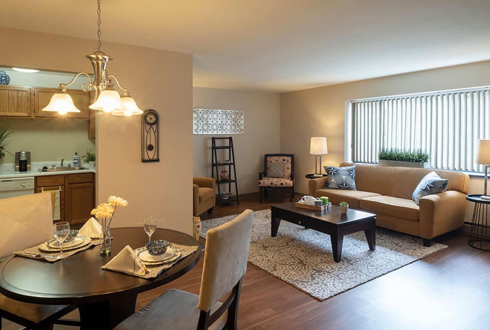 Living room and dining area with wood-style flooring at Maiden Bridge & Canongate Apartments in Pittsburgh, Pennsylvania