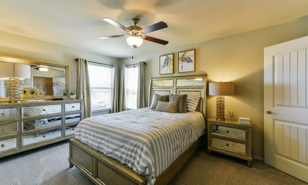 Cozy master bedroom with ceiling fan at Cottages at Abbey Glen Apartments in Lubbock, Texas