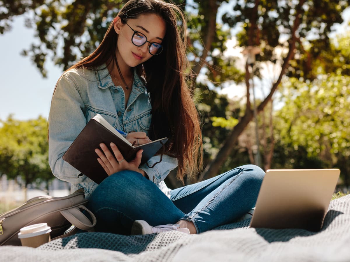 Student taking advantage of a beautiful and studying in a park near University Village in Greensboro, North Carolina