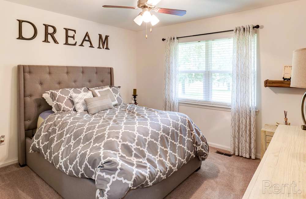 Cozy modern bedroom with plush bedding and natural light at Avian Place Apartments in North Charleston, South Carolina