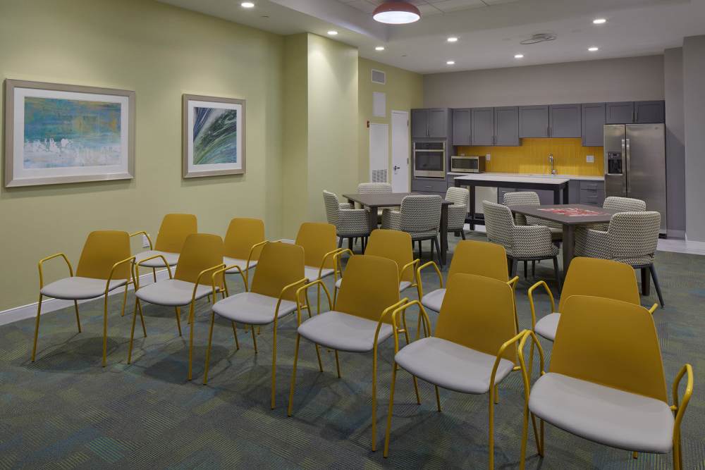 Community room with chairs and wall paintaings at Senior Residence at The Machon in Swampscott, Massachusetts