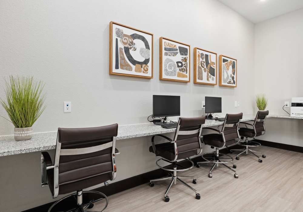 Business center with computers and wood flooring at Balcones Trails in Kyle, Texas