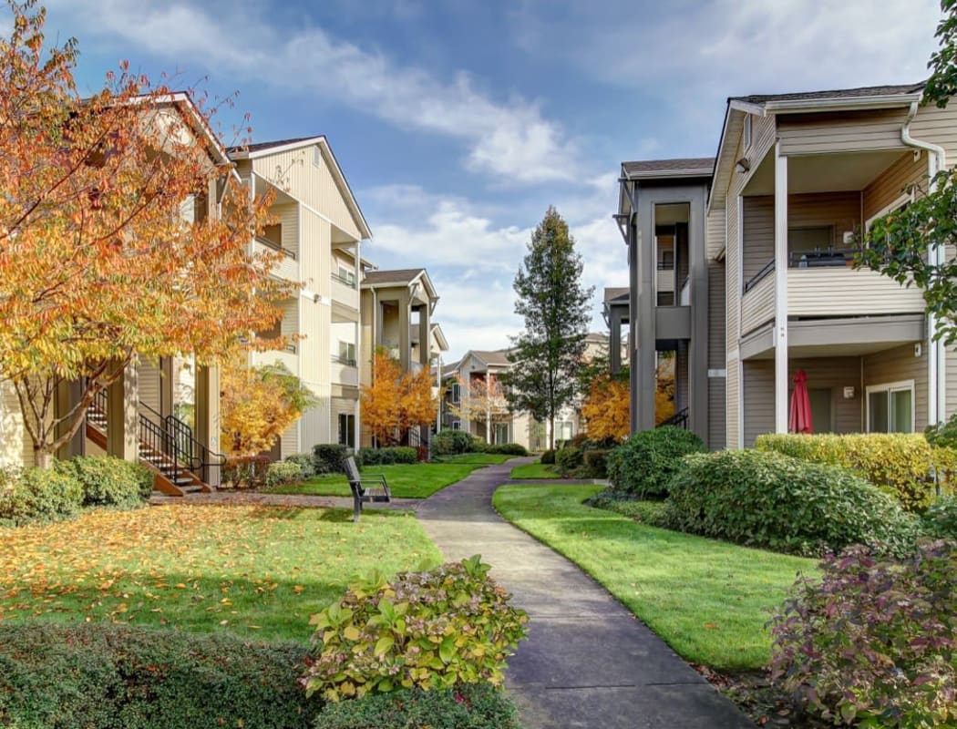 Beautiful autumn view of a well-maintained exterior common area between resident buildings at River Trail Apartments in Puyallup, Washington