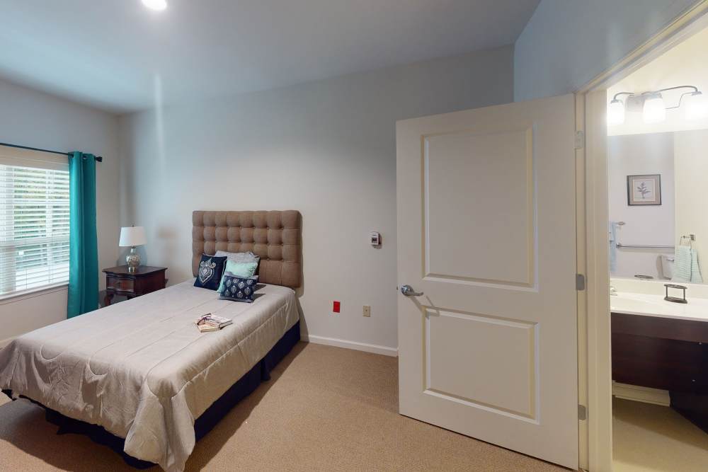 Bedroom with large comfortable bed and connected bathroom at Harmony on the Peninsula in Yorktown, Virginia