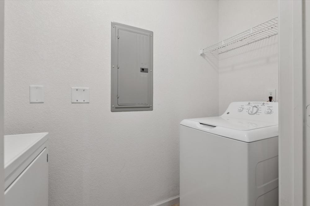 Well-appointed laundry room with modern appliances at Covington Woods Apartments in Lansing, Kansas.