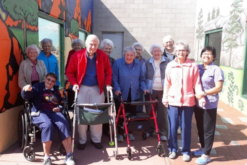 Gathering of residents outside on a sunny day at HeatherWood Assisted Living & Memory Care in Eau Claire, Wisconsin. 