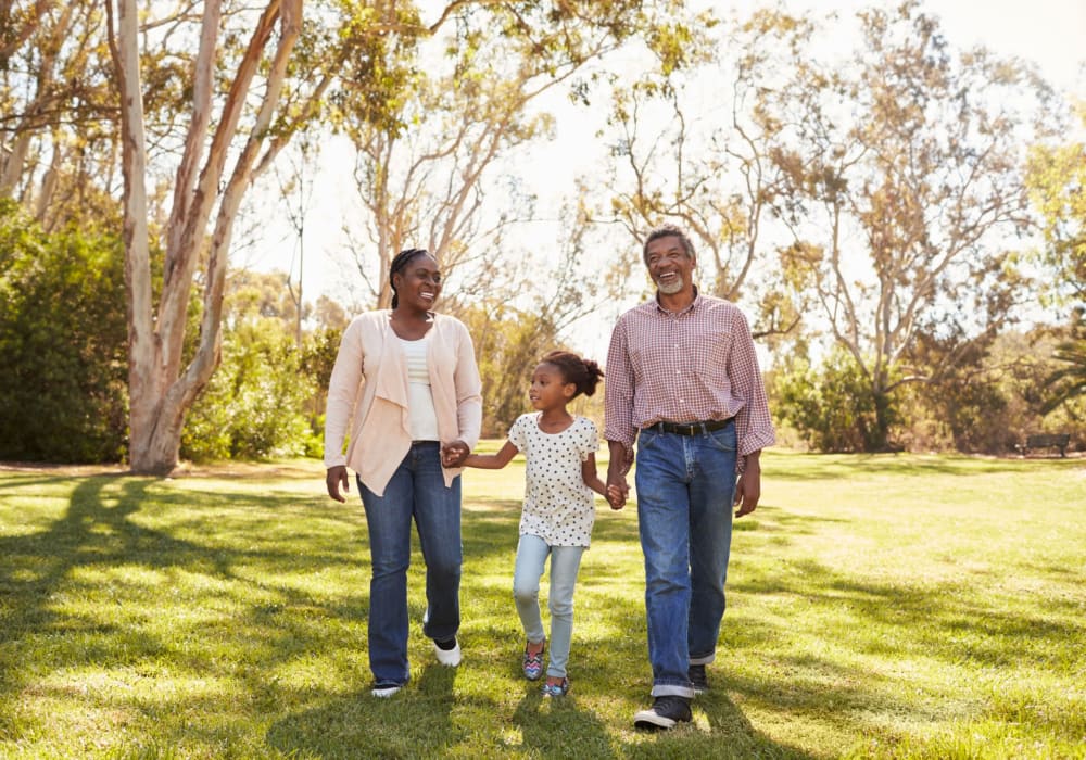 Resident couple enjoying a stroll with daughter in a park near The Villas at Woodland Hills in Woodland Hills, California