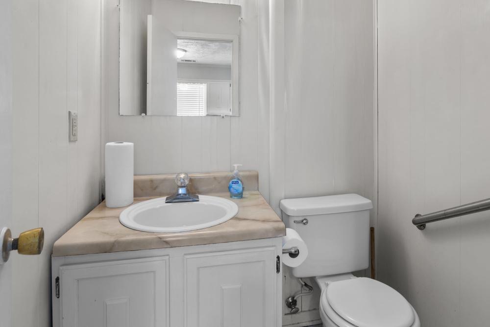 Bright and welcoming bathroom featuring elegant marble countertops and a classic mirror at Pecan Ridge in Vicksburg, Mississippi.