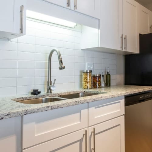 Stainless-steel appliances and granite counters in an apartment kitchen at Webb Bridge Crossing in Alpharetta, Georgia
