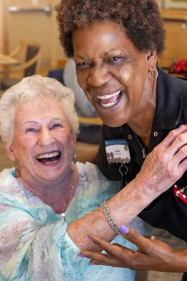 Resident and team member laughing and hugging at Merrill Gardens in Seattle, Washington