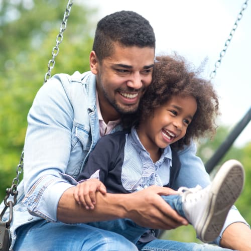 A father pushing his son on the swing near Bonita Bluffs in San Diego, California