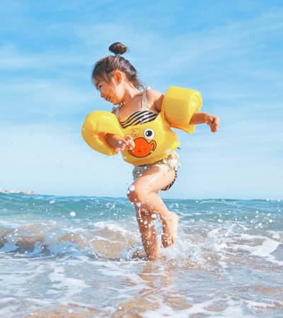 A happy kid having a good time on a beach near 1900 Ocean Apartment Homes in Long Beach, California
