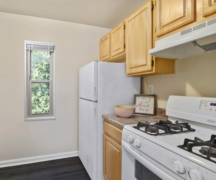 Kitchen with range, refrigerator and wooden cabinets at Laurel Manor in Laurel, Maryland