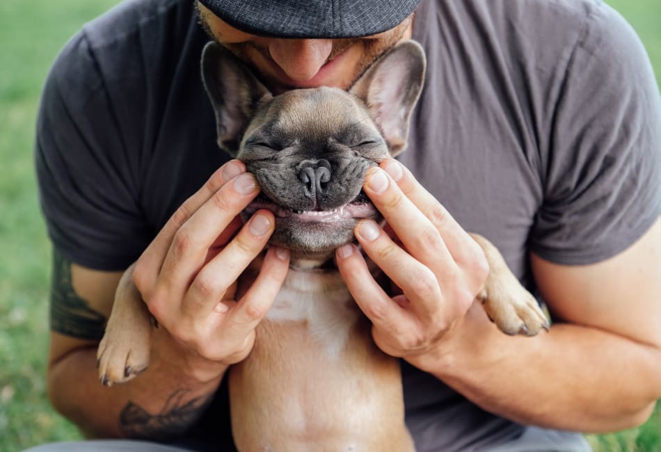 Resident posing for a photo with his puppy outside their new home at Vue Los Feliz in Los Angeles, California