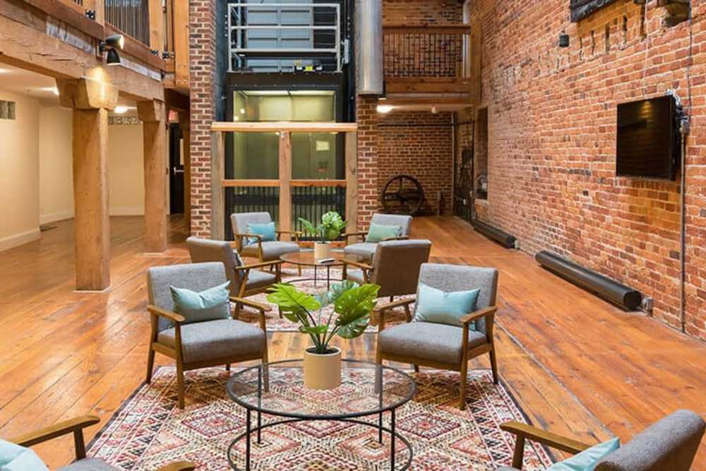 Clubhouse lounge area with wall-mounted TV at High Street Lofts in Petersburg, Virginia