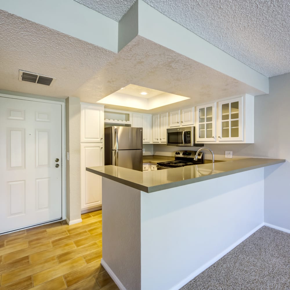 Model home's entryway and kitchen with hardwood flooring at Sofi Irvine in Irvine, California