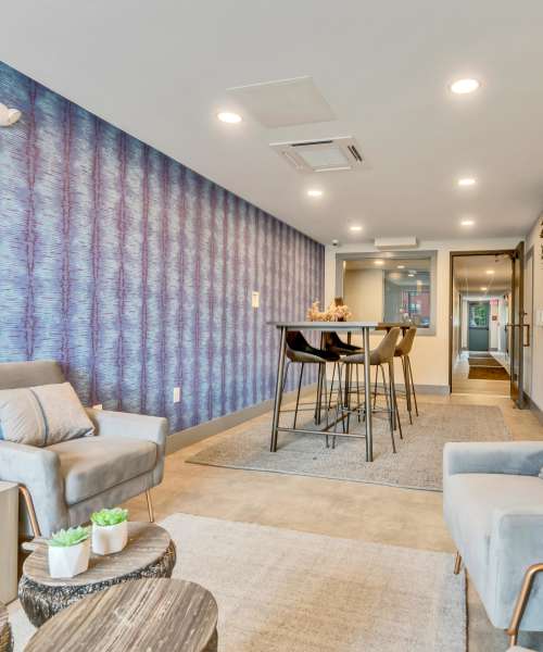Seating area with gray chairs and table at Latitude at South Portland in Portland, Maine