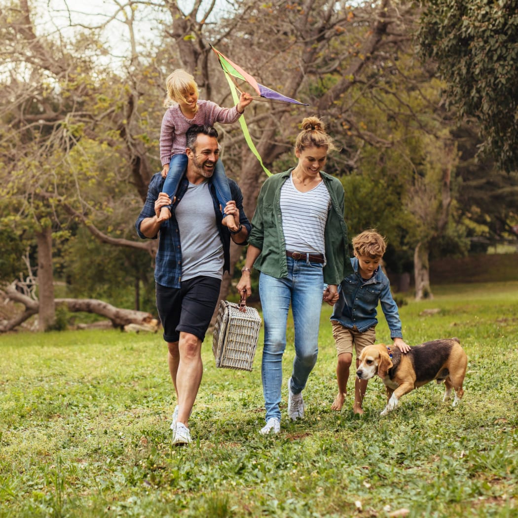 Family walking their dog outside at Cottages at Abbey Glen Apartments in Lubbock, Texas