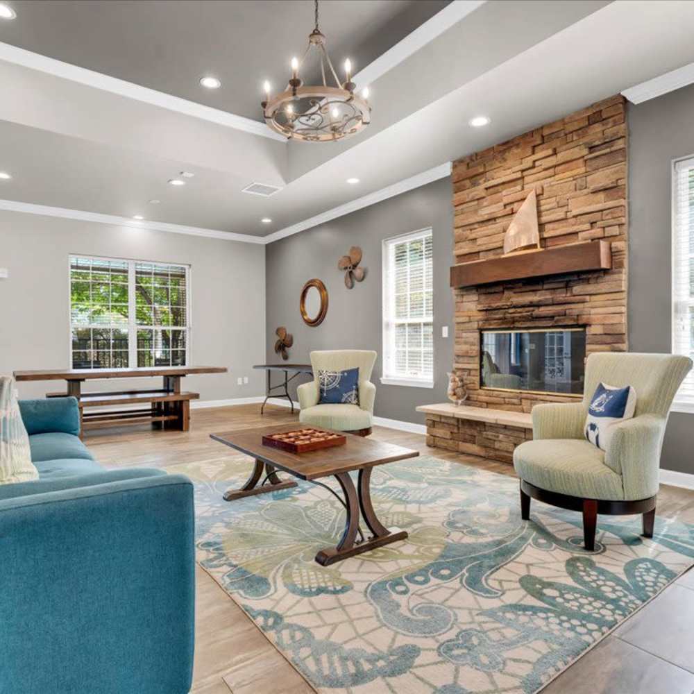 Bright community lounge with comfortable seating, stone fireplace, and large windows for natural light at 43 North Apartments in Grand Haven, Michigan