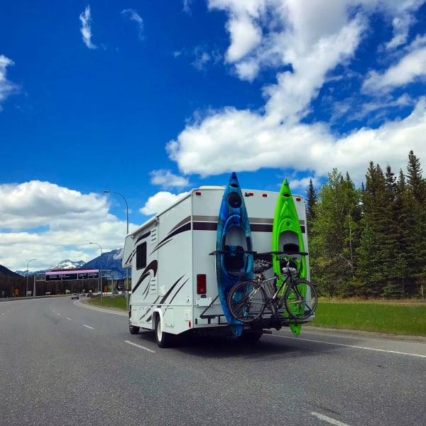 An RV with kayaks and a bike on the back near StorQuest RV & Boat Storage in Wilsonville, Oregon