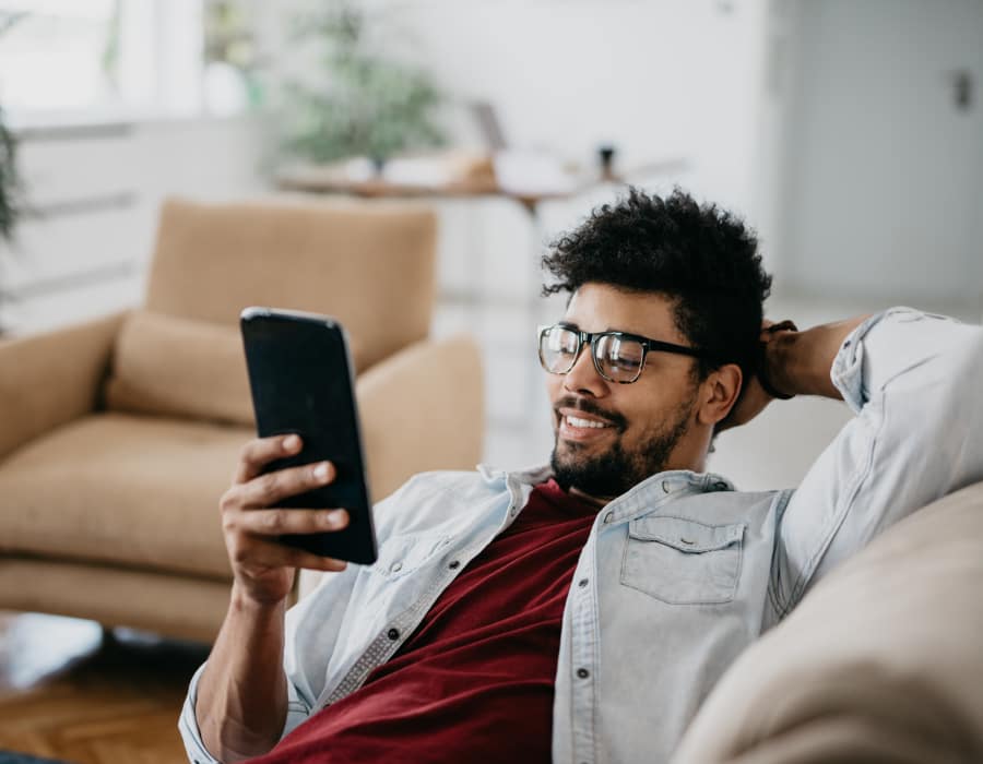 Man relaxing in his apartment at North Square Apartments at The Mill District in Amherst, Massachusetts