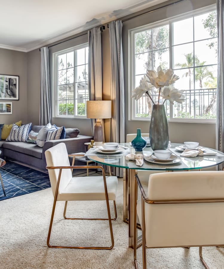 Open-concept living and dining areas with plush carpeting and accent walls in a model home at Sofi Highlands in San Diego, California