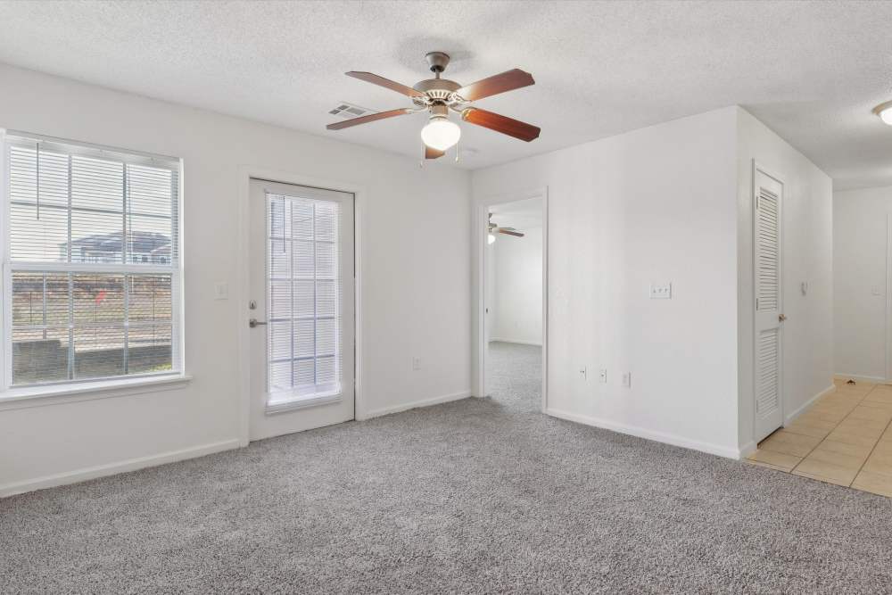 Spacious living area with cozy carpet and natural light at Covington Woods Apartments in Lansing, Kansas.