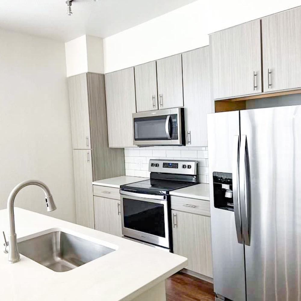 Spacious kitchen with sink in island stainless steel appliances and modern cabinets at The Alcott in Denver, Colorado